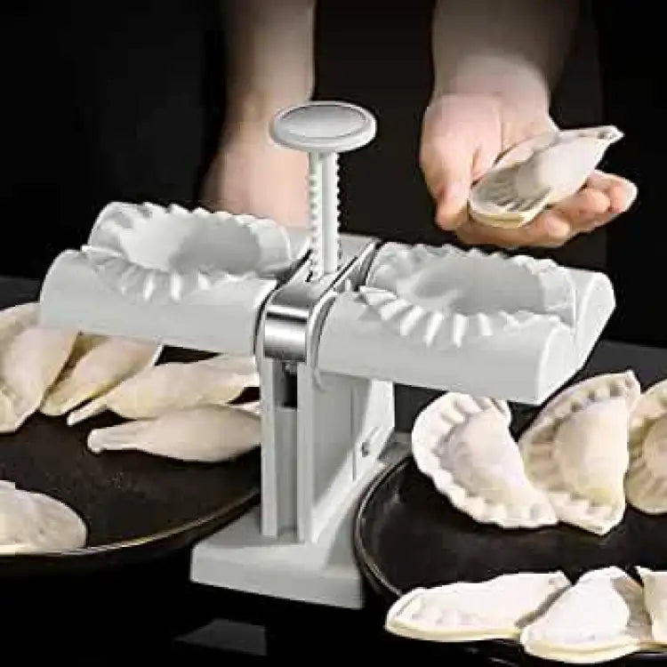 Double head dumpling maker in use with finished dumplings on plates